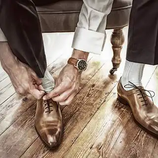 Photographe mariage Toulouse : préparatifs du marié, enfilage des chaussures avant la cérémonie