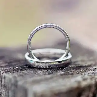 Photographe mariage Toulouse : gros plan des alliances sur un tronc d’arbre, inspiration mariage nature
