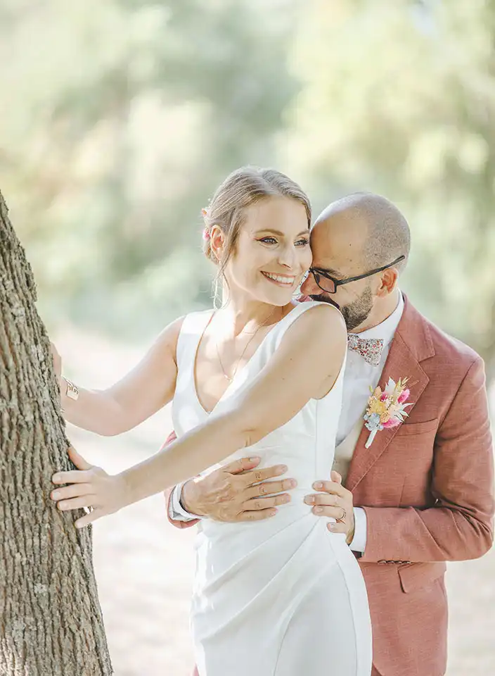Les mariés Melodye et Alexandre souriants, mêlant amour, complicité et une sensualité palpable.