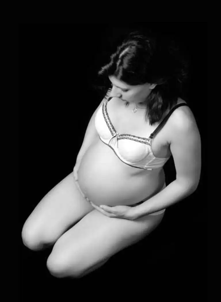 Future maman rayonnante immortalisant la douceur de la maternité lors d’une séance photo grossesse